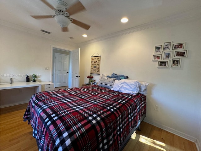 bedroom featuring ceiling fan, hardwood / wood-style floors, and crown molding