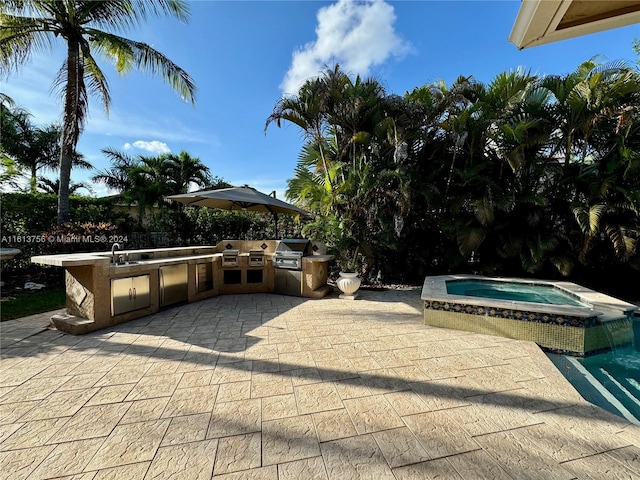 view of patio / terrace with an in ground hot tub, grilling area, and an outdoor kitchen