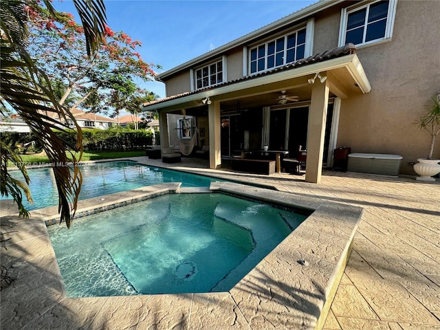 view of pool with an in ground hot tub, a patio area, and ceiling fan