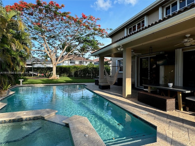 view of pool with a patio, an in ground hot tub, ceiling fan, and a lawn