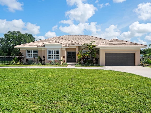 mediterranean / spanish-style house featuring a garage and a front lawn