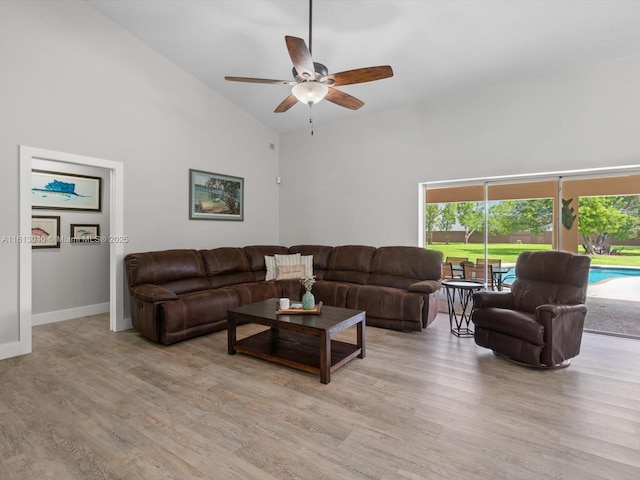 living room featuring light hardwood / wood-style floors, high vaulted ceiling, and ceiling fan