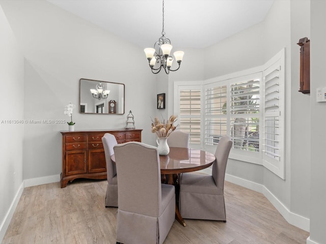 dining area with light hardwood / wood-style flooring and a chandelier