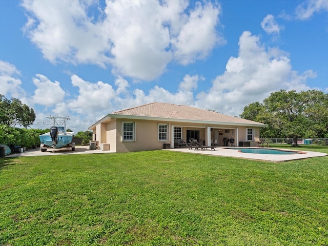 rear view of house with a lawn and a patio