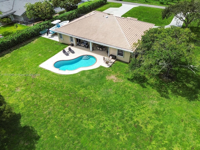 view of swimming pool with a patio area and a yard