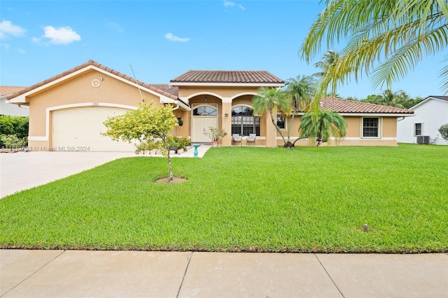 mediterranean / spanish-style house featuring stucco siding, concrete driveway, and a front yard