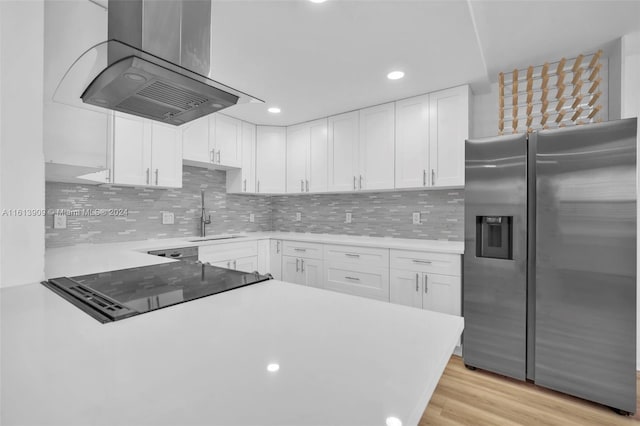 kitchen featuring sink, backsplash, white cabinetry, stainless steel fridge with ice dispenser, and island exhaust hood