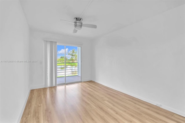 empty room with ceiling fan and light hardwood / wood-style flooring