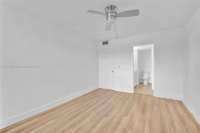 unfurnished bedroom featuring a closet, ceiling fan, ensuite bathroom, and light hardwood / wood-style flooring