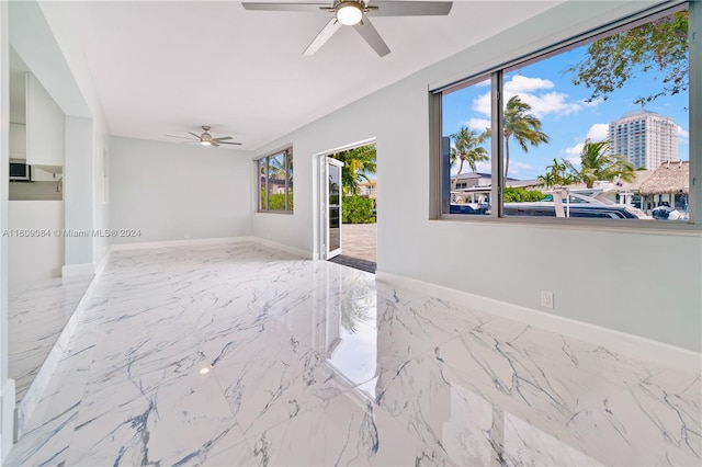 empty room featuring a wealth of natural light and ceiling fan