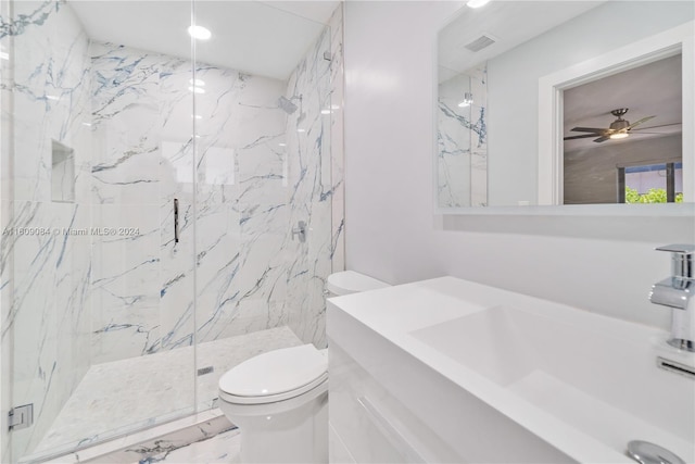 bathroom with vanity, ceiling fan, toilet, and a shower with shower door