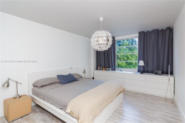 3 Island Ave Unit 04J, Miami Beach, FL 33139 - bedroom with a notable chandelier and light wood-type flooring