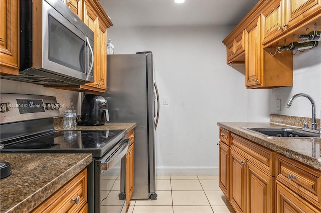 kitchen featuring light tile patterned flooring, appliances with stainless steel finishes, and sink