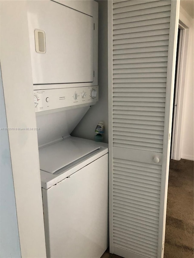 laundry area with stacked washer / dryer and carpet floors