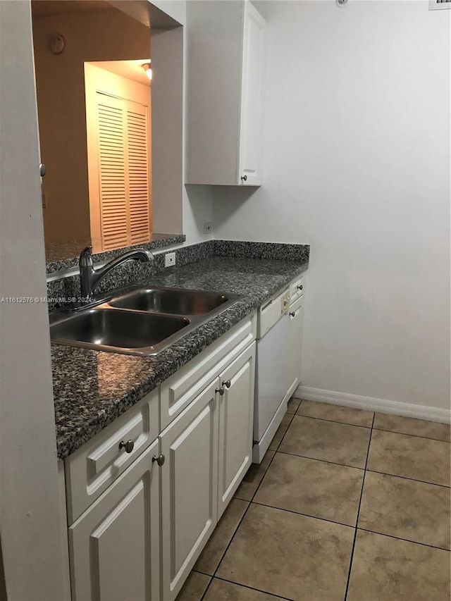 kitchen featuring sink, white dishwasher, tile patterned floors, and white cabinets