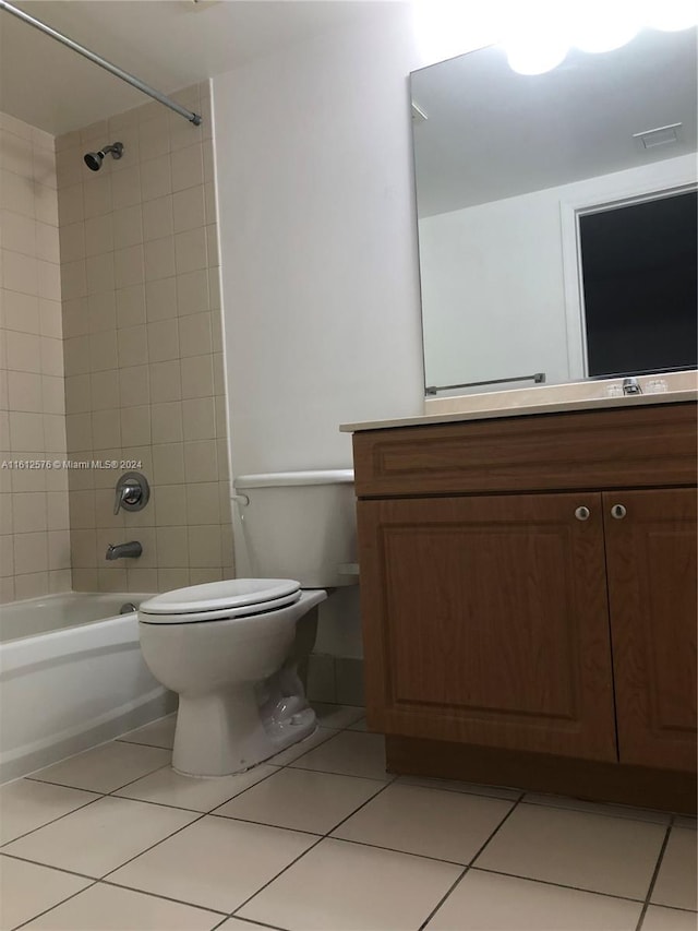 full bathroom featuring tile patterned floors, tiled shower / bath, vanity, and toilet