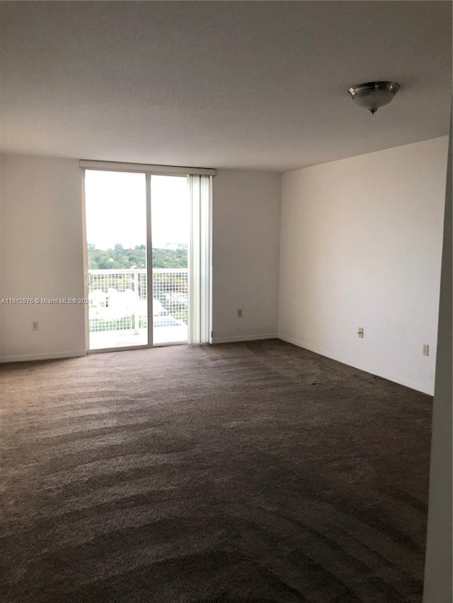 unfurnished room featuring dark colored carpet