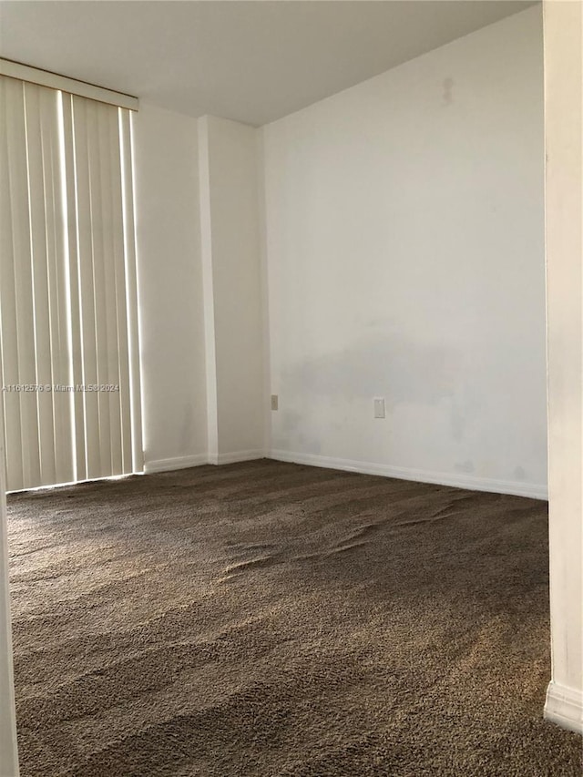 empty room featuring dark colored carpet