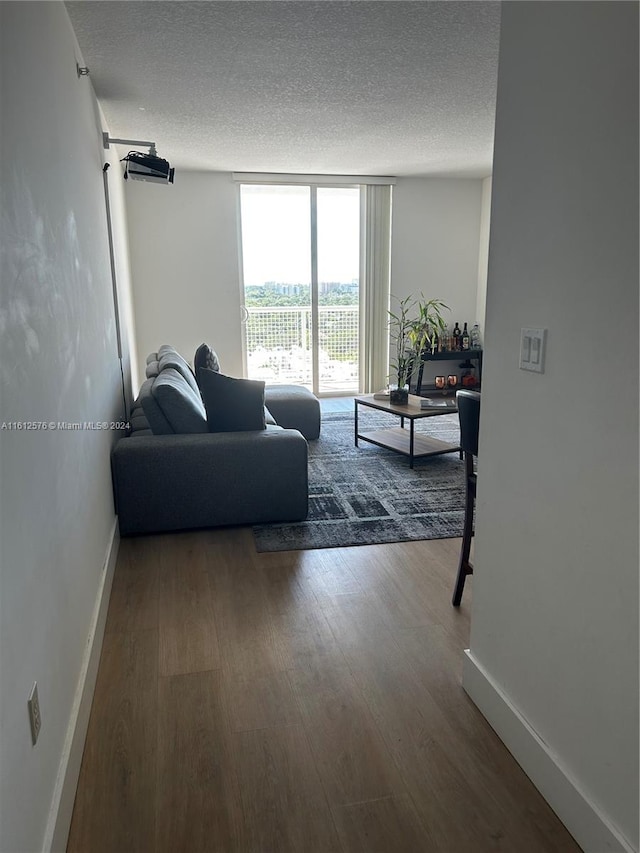 living room with floor to ceiling windows, a textured ceiling, and hardwood / wood-style floors