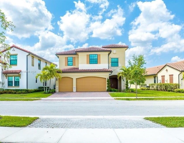 mediterranean / spanish-style home with a front yard and a garage