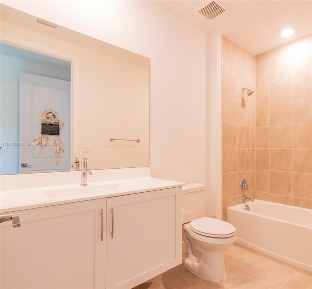 full bathroom featuring tile patterned flooring, vanity, tiled shower / bath combo, and toilet