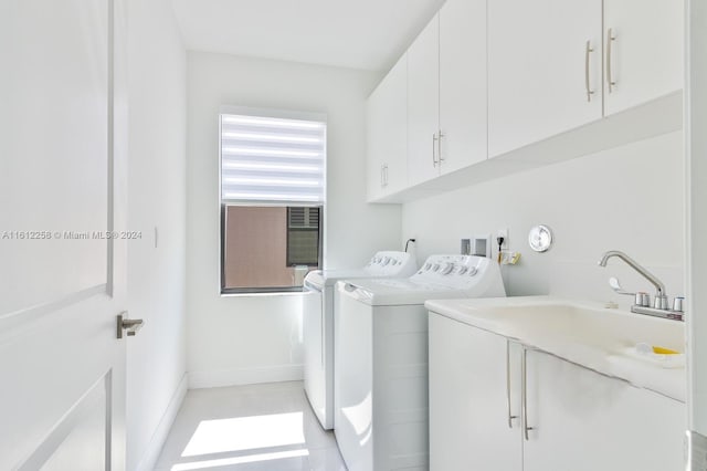 clothes washing area with cabinets and independent washer and dryer