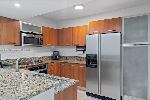 kitchen featuring light stone countertops, kitchen peninsula, and appliances with stainless steel finishes