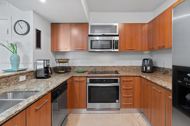 kitchen with stainless steel appliances, light stone counters, and light tile patterned flooring