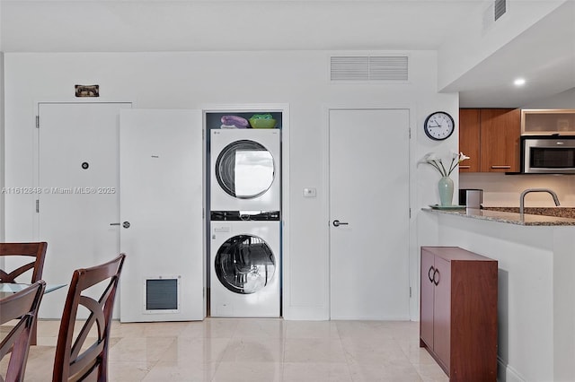 laundry area with stacked washer and clothes dryer