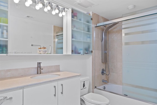 full bathroom featuring shower / bath combination with glass door, vanity, and toilet