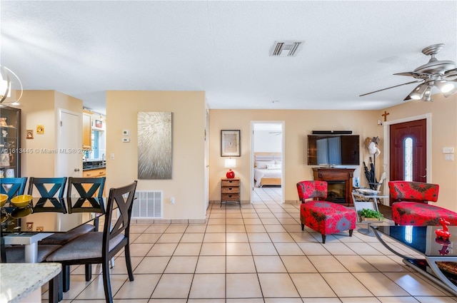 tiled living room featuring a textured ceiling and ceiling fan