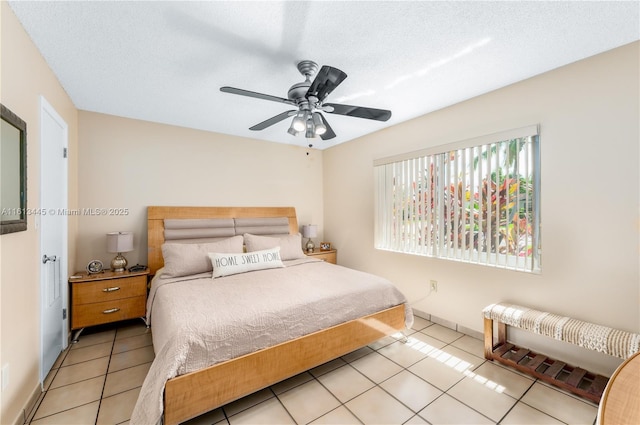 tiled bedroom featuring a textured ceiling and ceiling fan