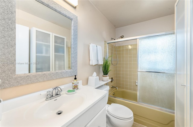 full bathroom featuring vanity, bath / shower combo with glass door, and toilet