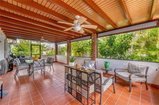 sunroom / solarium with beam ceiling and ceiling fan