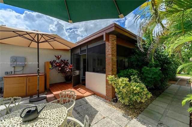 view of patio / terrace with a sunroom and a jacuzzi