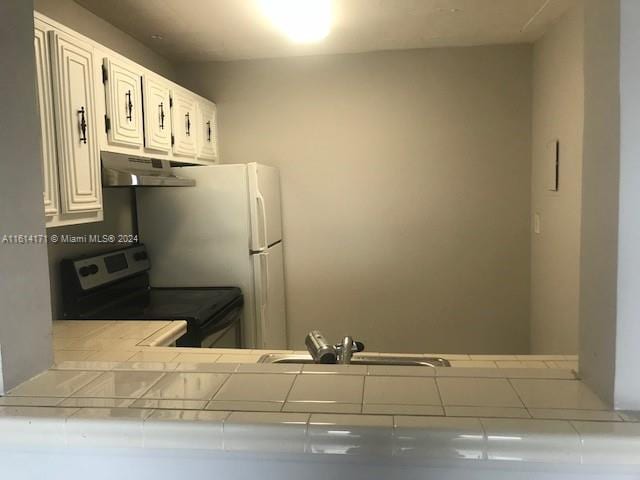 kitchen featuring white cabinetry, sink, tile countertops, and electric stove