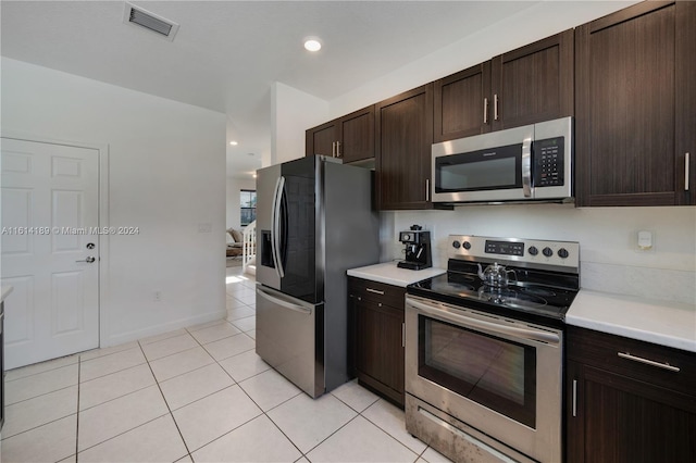 kitchen featuring appliances with stainless steel finishes, dark brown cabinets, and light tile patterned floors