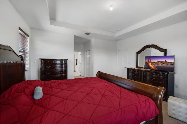 bedroom with carpet flooring and a tray ceiling