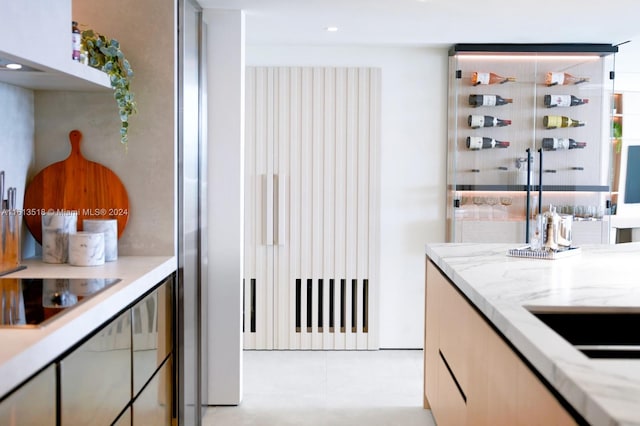 kitchen with black electric cooktop and light stone counters