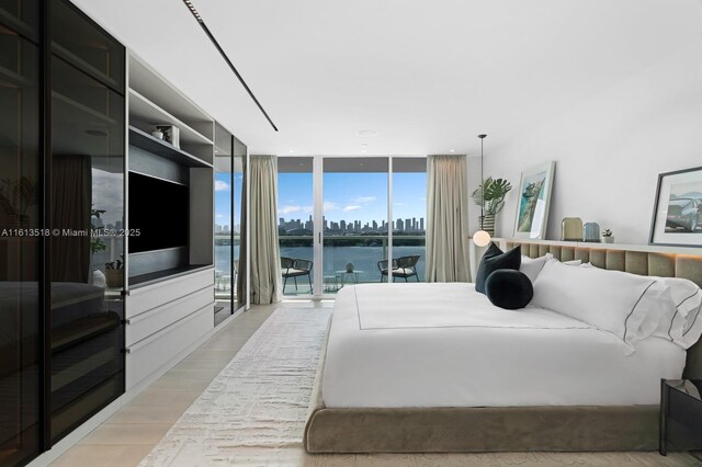 bedroom featuring light wood-type flooring, access to exterior, and a wall of windows