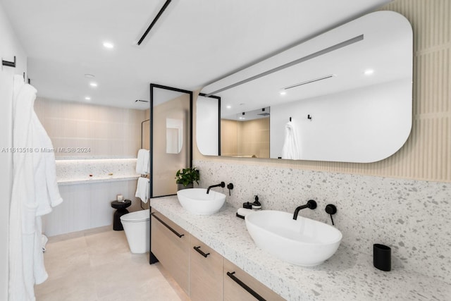 bathroom with vanity, backsplash, and toilet