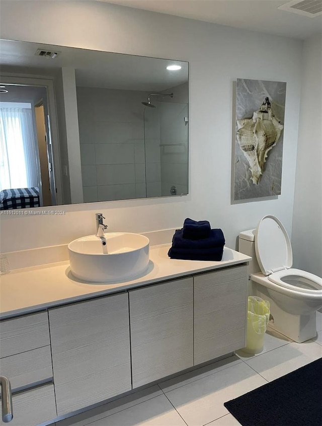 bathroom with tile flooring, vanity, and toilet