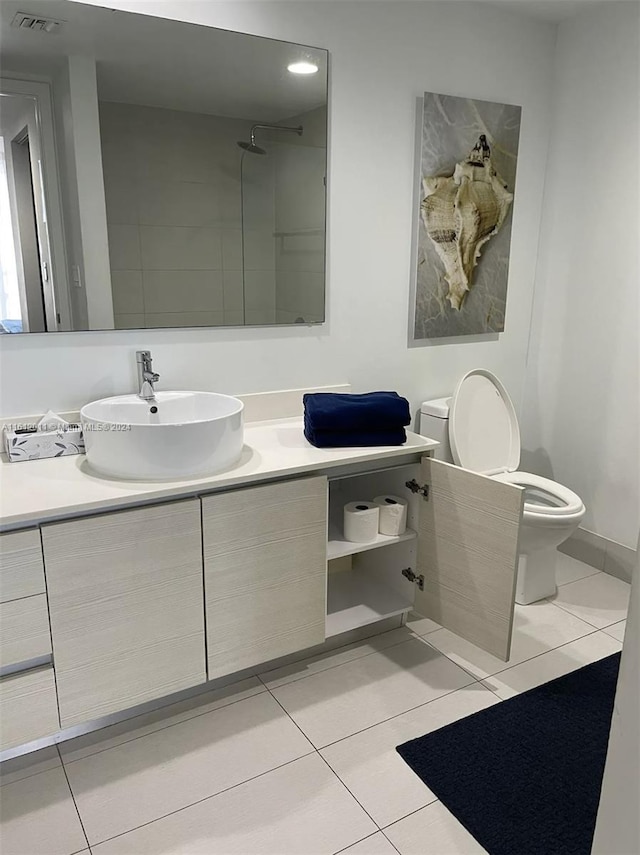 bathroom with tile floors, vanity, and toilet