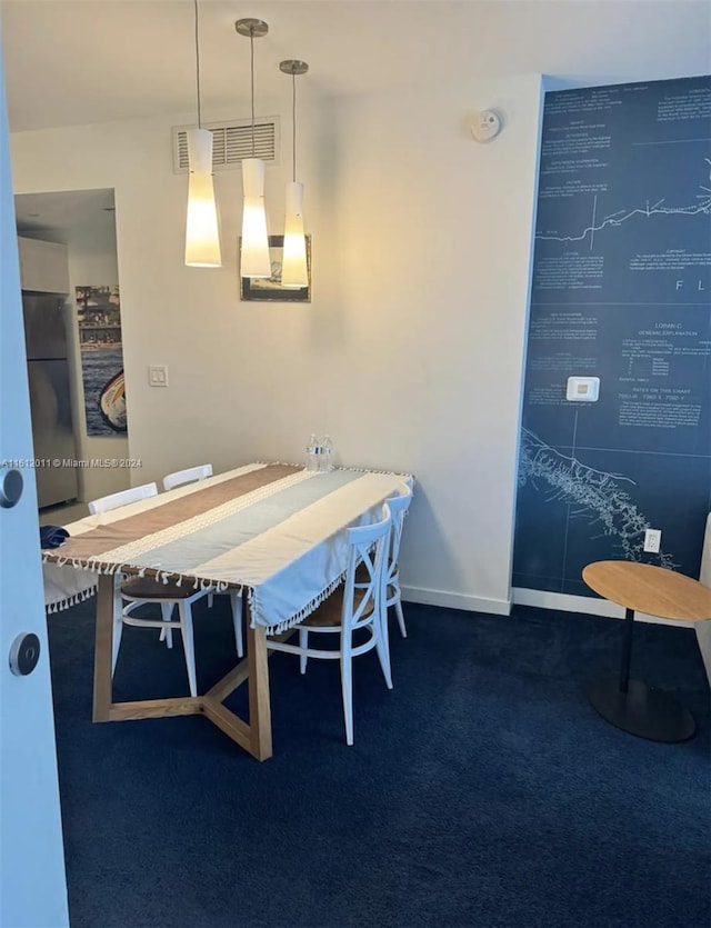 dining space featuring dark carpet