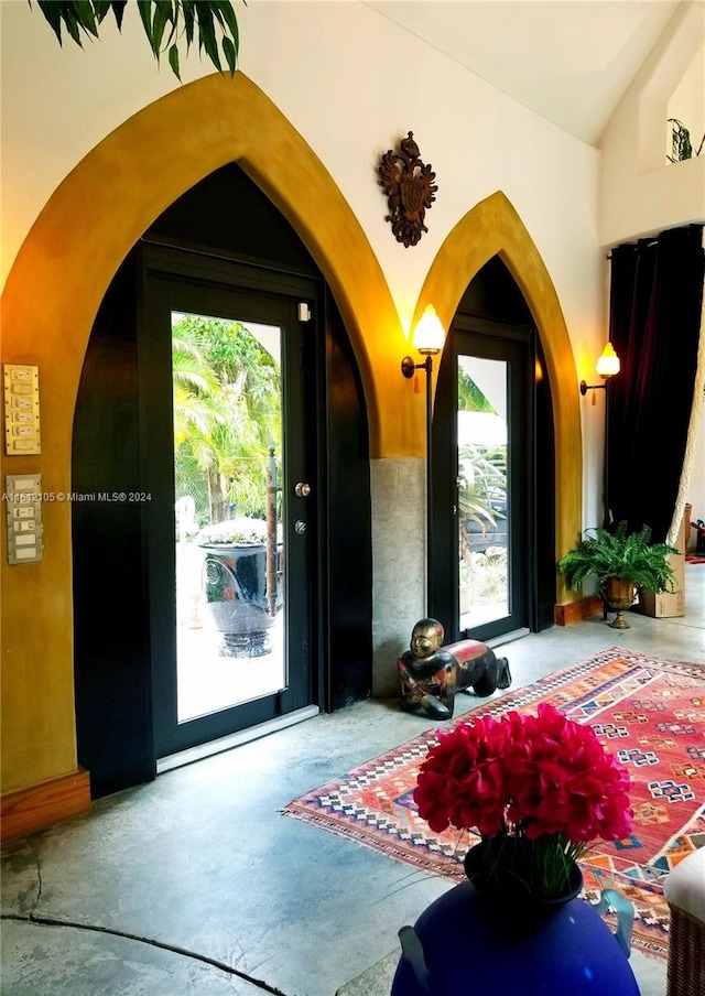 entrance foyer featuring concrete floors and vaulted ceiling