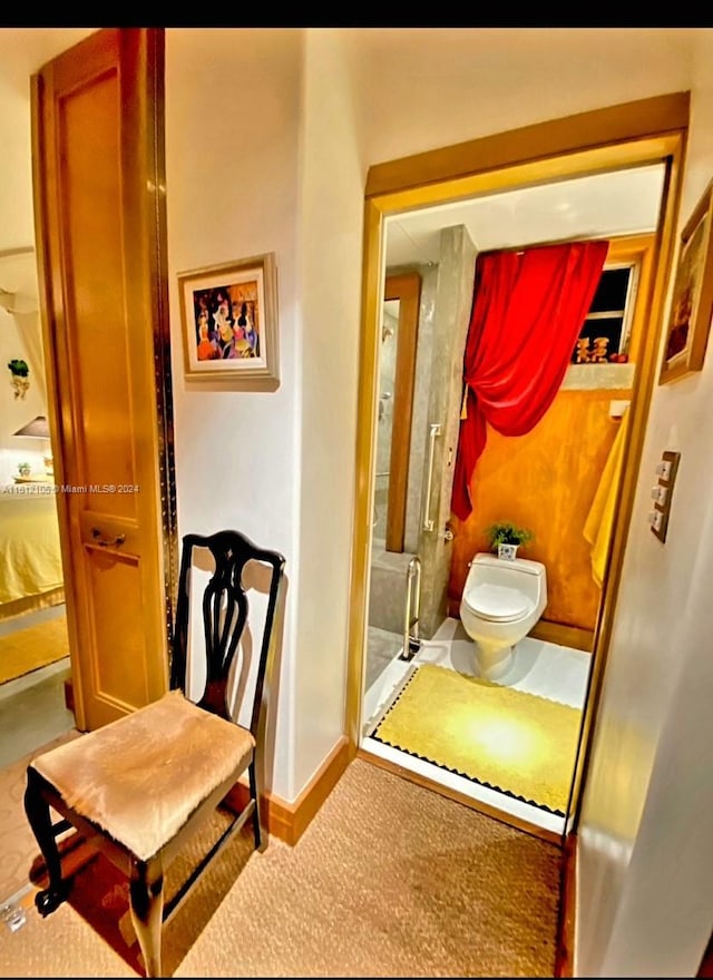 bathroom with toilet and a shower with shower door