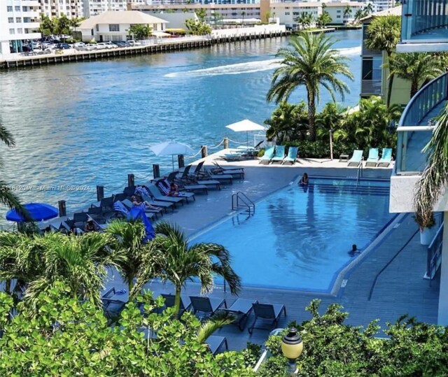 view of swimming pool with a patio area and a water view