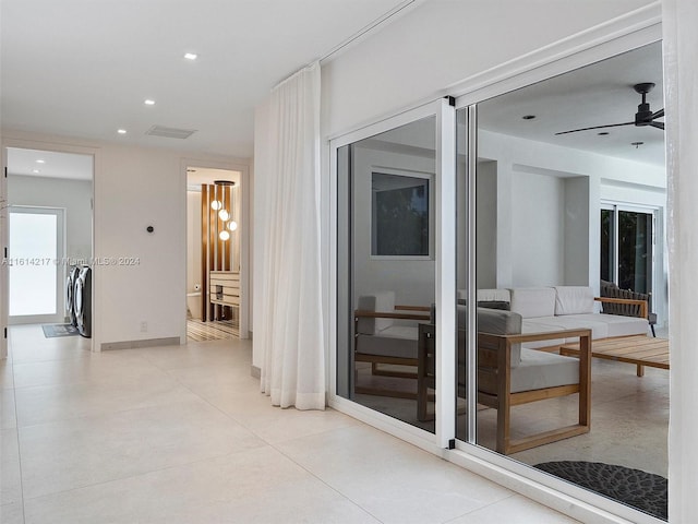 hallway featuring separate washer and dryer and light tile patterned floors