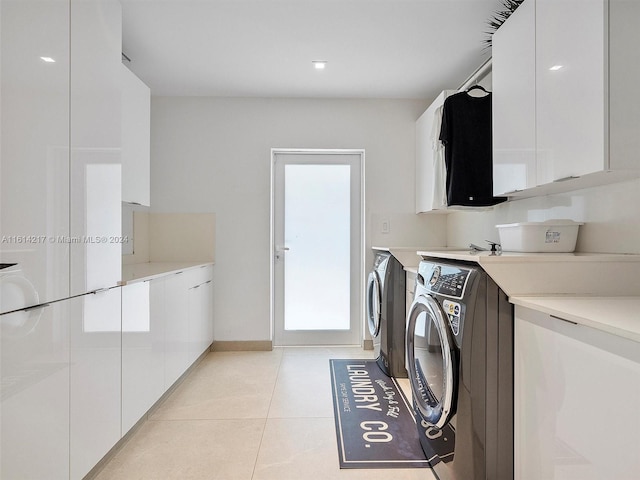 clothes washing area with independent washer and dryer, cabinets, light tile patterned floors, and a wealth of natural light