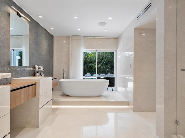 bathroom featuring vanity, tile walls, and a washtub